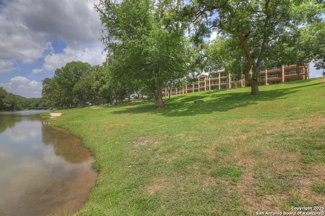 a view of a fountain in front of a house with a big yard