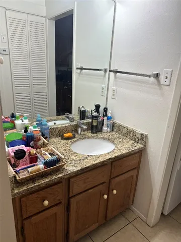 a bathroom with a granite countertop sink a mirror and shower