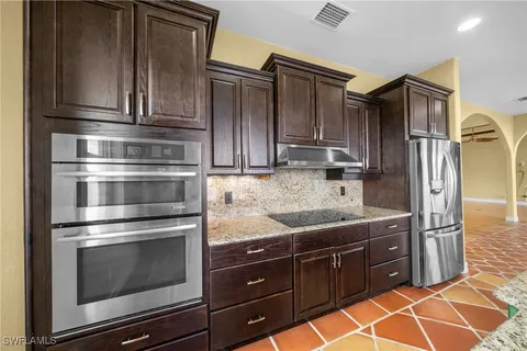 a kitchen with granite countertop stainless steel appliances and wooden cabinets