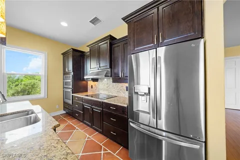a kitchen with stainless steel appliances granite countertop a refrigerator and a sink