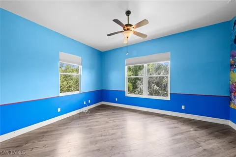 an empty room with windows and fan