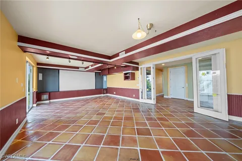 a view of an empty room with a birdcage and a potted plant
