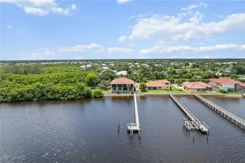 an aerial view of residential houses with outdoor space and lake view