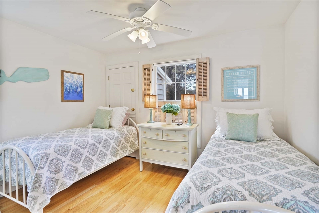 31 The Boulevard Edgartown, MA 02539 - Photo 21 of 39 a bedroom with a large bed and a chandelier