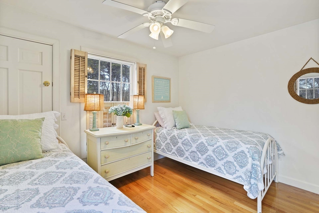 31 The Boulevard Edgartown, MA 02539 - Photo 22 of 39 a bedroom with a bed and a chandelier