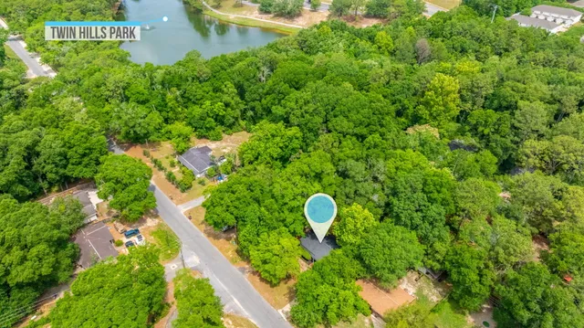 a view of a tennis ground with large trees