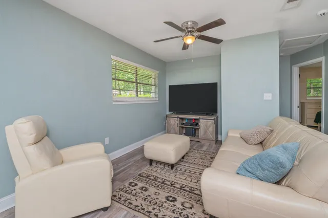 a living room with furniture a flat screen tv and a window