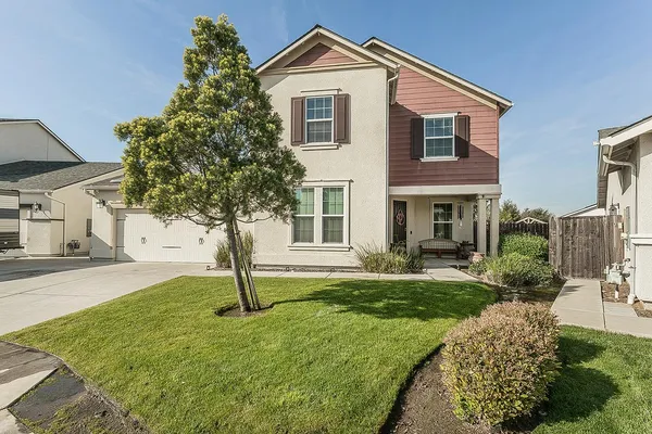 a front view of a house with a yard and garage