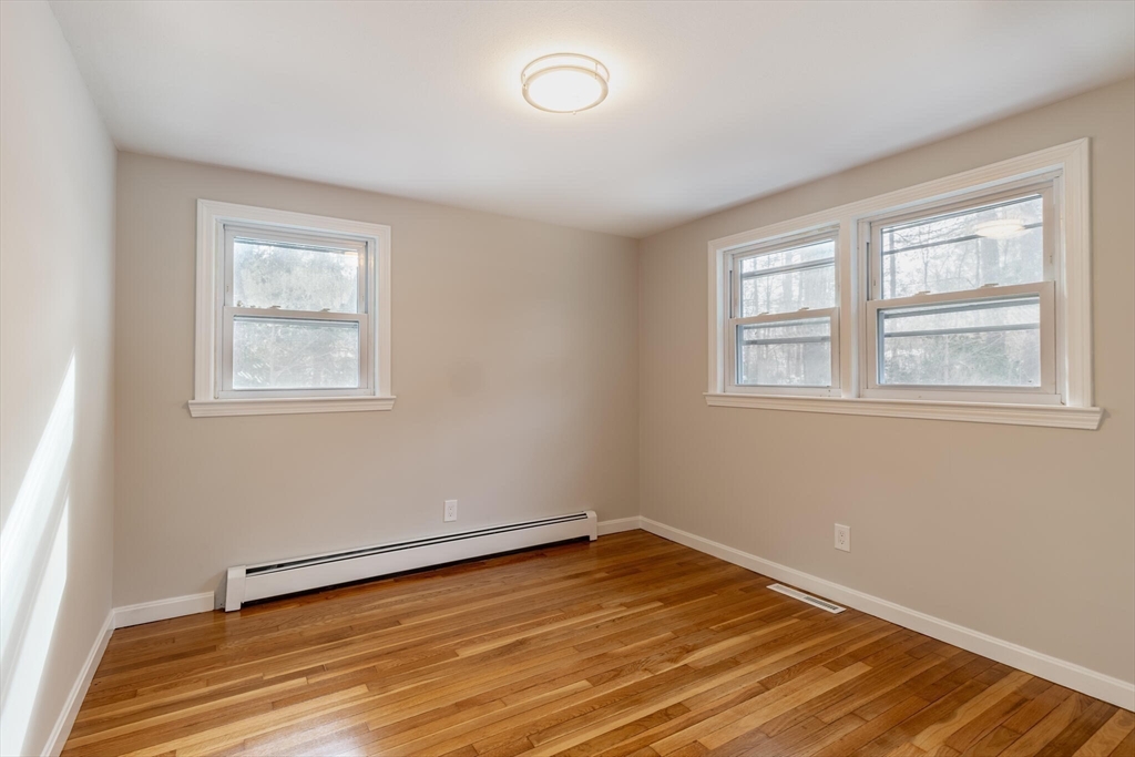 123 Lowell Road Pepperell, MA 01463 - Photo 15 of 30 an empty room with wooden floor and windows