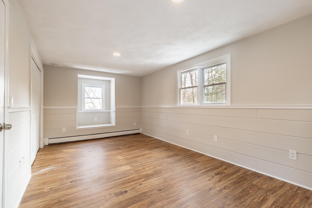 123 Lowell Road Pepperell, MA 01463 - Photo 18 of 30 an empty room with wooden floor and windows