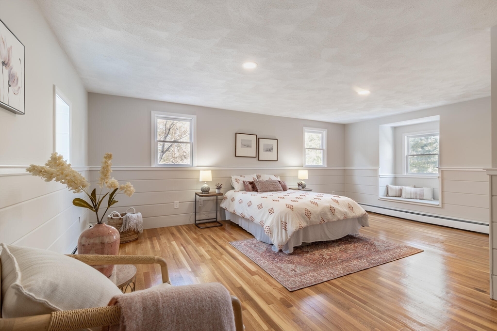 123 Lowell Road Pepperell, MA 01463 - Photo 9 of 30 a spacious bedroom with a bed and wooden floor