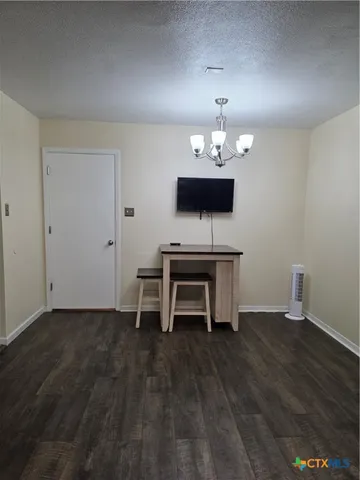 a dining room with wooden floor and a chandelier