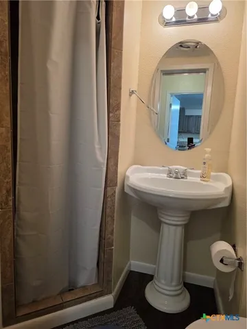 a bathroom with a sink toilet and mirror