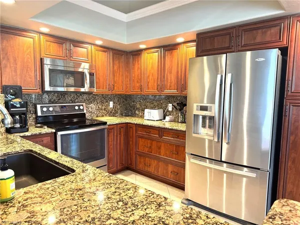 a kitchen with a refrigerator sink and cabinets