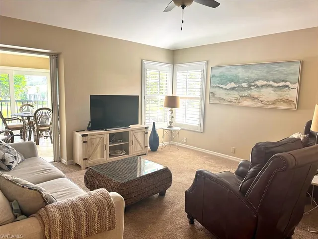 a living room with furniture a large window and a flat screen tv