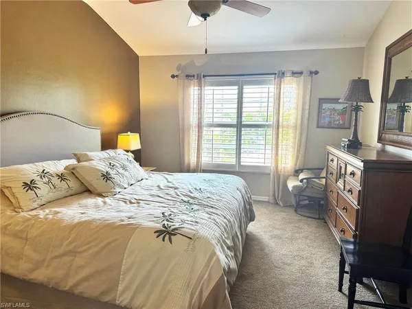 a bedroom with a bed flat screen tv and a large window
