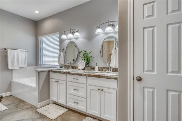 a bathroom with a double vanity sink and a mirror