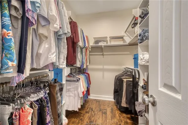 a view of walk in closet with clothes and shoes