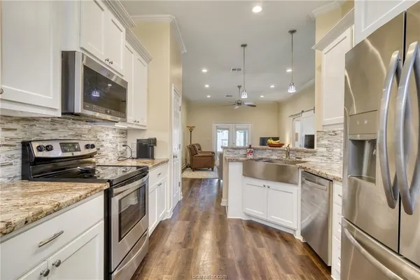 a kitchen with stainless steel appliances granite countertop a refrigerator a stove top oven a sink and dishwasher