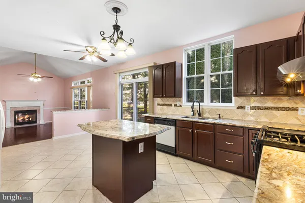 a large kitchen with kitchen island granite countertop a sink counter space appliances and a center island