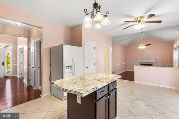 a kitchen with kitchen island a counter top space appliances and cabinets