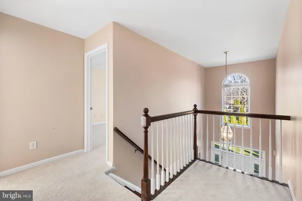 a view of staircase with railing and white walls