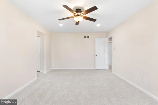 an empty room with chandelier fan