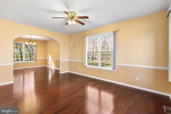 a view of an empty room with window and wooden floor