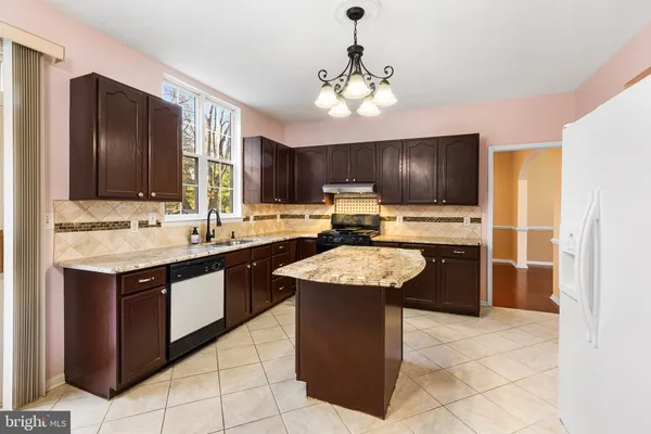 a kitchen with stainless steel appliances granite countertop wooden cabinets a sink and dishwasher