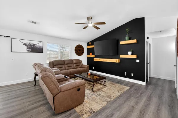 a living room with furniture and wooden floor