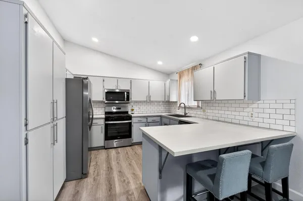 a kitchen with a sink a microwave a stove and refrigerator