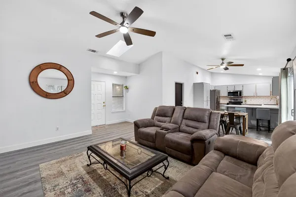 a living room with furniture and a wooden floor