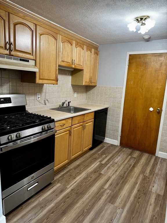 30 Worthen Street, Unit C4 Chelmsford, MA 01824 - Photo 4 of 8 a kitchen with stainless steel appliances granite countertop a stove a sink and a microwave
