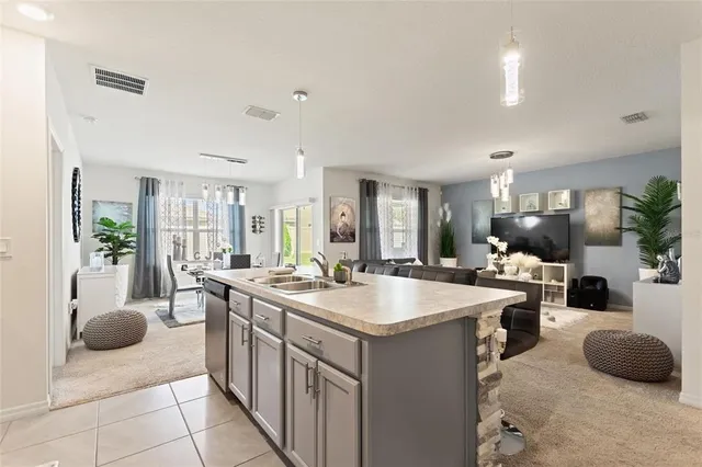 a large kitchen with kitchen island a stove a sink dishwasher and cabinets with wooden floor