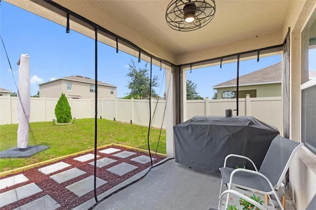 a living room with a bed furniture and a floor to ceiling window