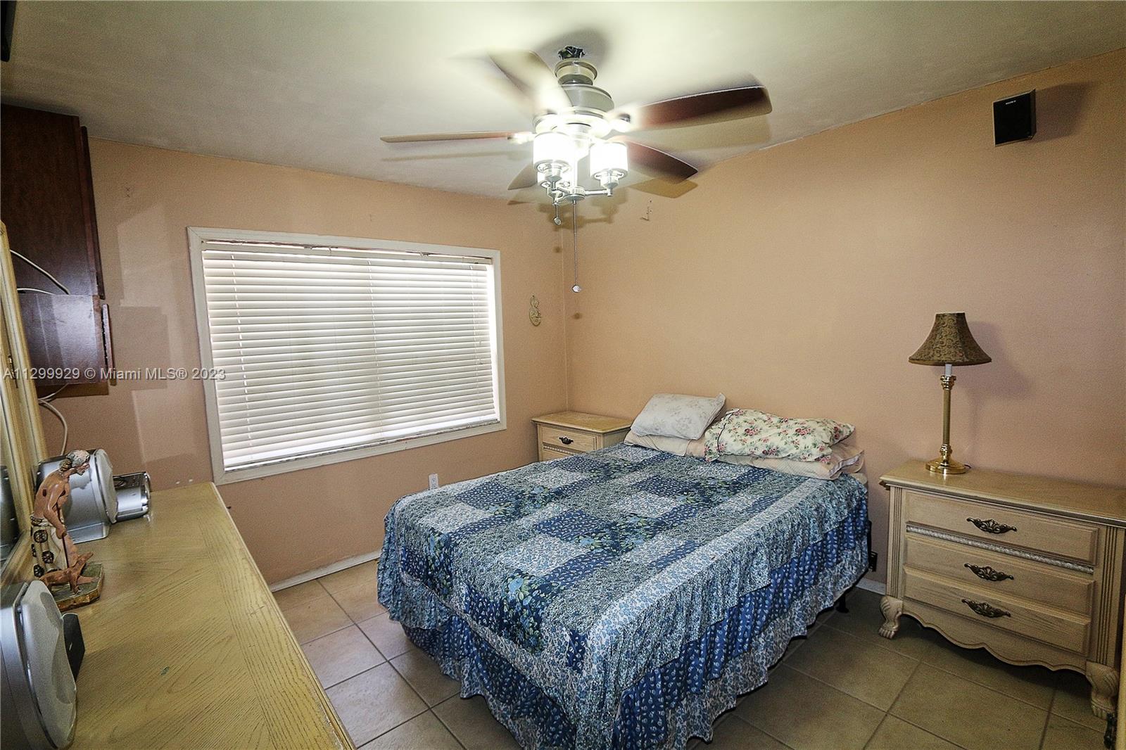 842 Southwest 89th Avenue, Unit A Miami, FL 33174 - Photo 19 of 34 a bedroom with a bed and a chandelier