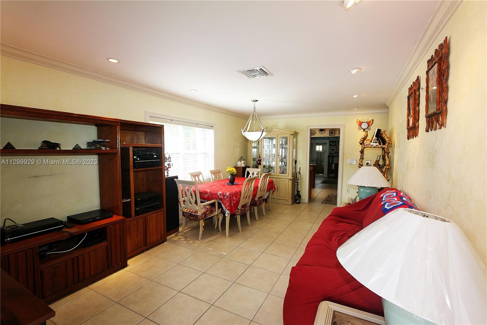 842 Southwest 89th Avenue, Unit A Miami, FL 33174 - Photo 7 of 34 a living room with furniture a flat screen tv and a refrigerator
