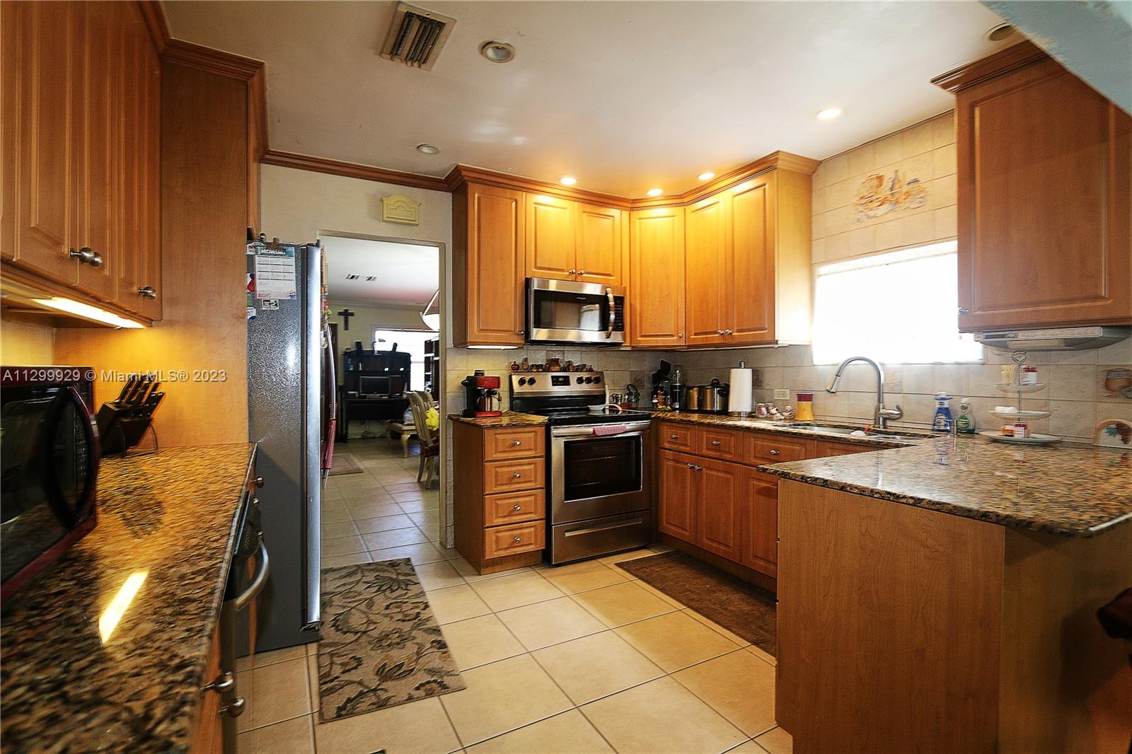 842 Southwest 89th Avenue, Unit A Miami, FL 33174 - Photo 9 of 34 a kitchen with stainless steel appliances granite countertop a refrigerator a stove and a sink