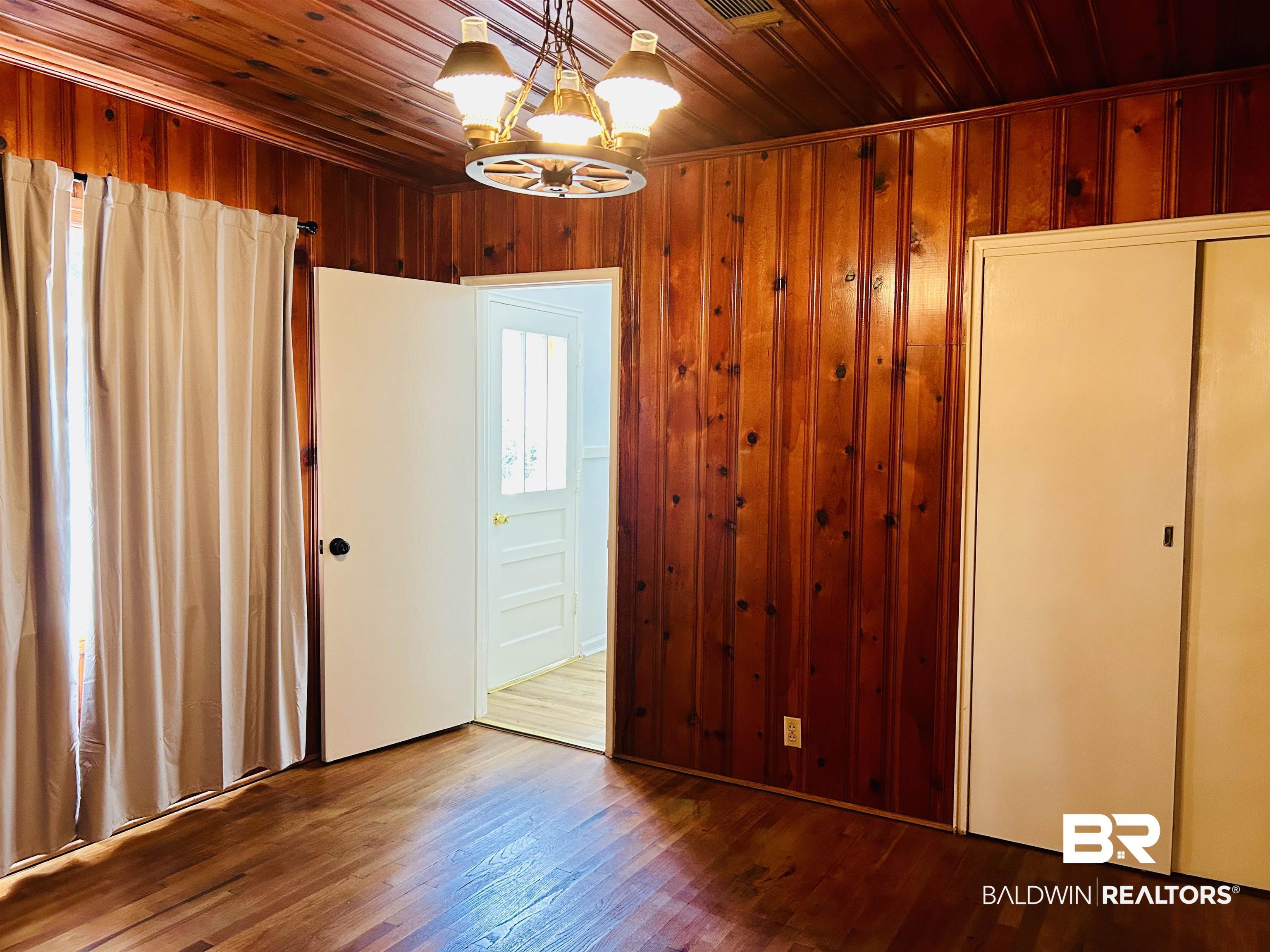 94 Diamond Street Mobile, AL 36611 - Photo 18 of 30 Unfurnished bedroom with an inviting chandelier, hardwood / wood-style floors, wooden ceiling, and wood walls