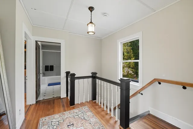 a view of a hallway with wooden floor and staircase