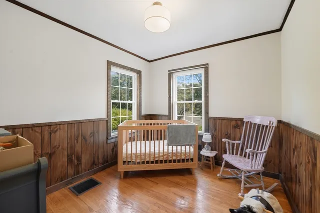 a view of a bedroom with furniture and wooden floor