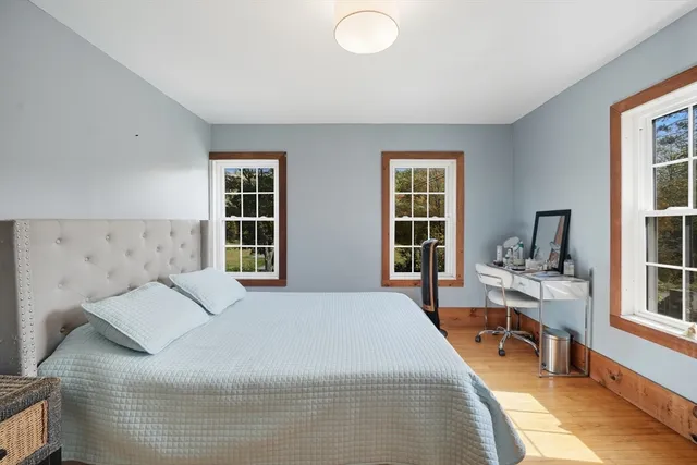 a bedroom with a bed and a large window