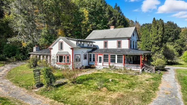 a front view of a house with a yard and potted plants