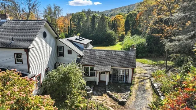 a aerial view of a house with a yard and large tree