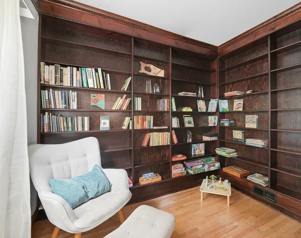 a living room with furniture a rug and a book shelf