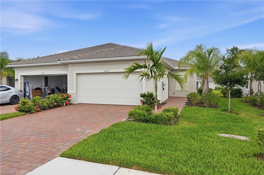 2215 Dragonfruit Way Naples, FL 34120 - Photo 2 of 38 a front view of a house with garden