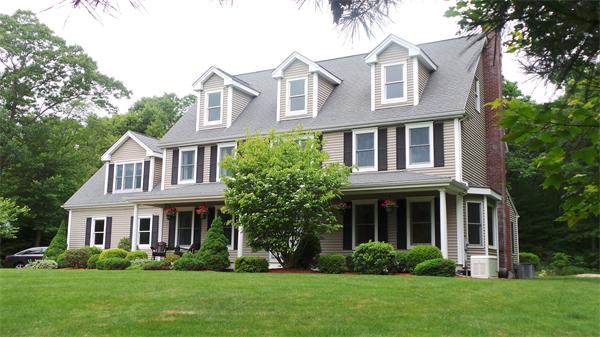 a front view of a house with a yard and trees