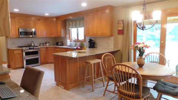 19 Carter Road Foxboro, MA 02035 - Photo 11 of 30 a kitchen with stainless steel appliances granite countertop a table chairs sink refrigerator and microwave