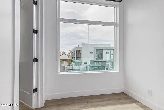 an empty room with wooden floor and windows