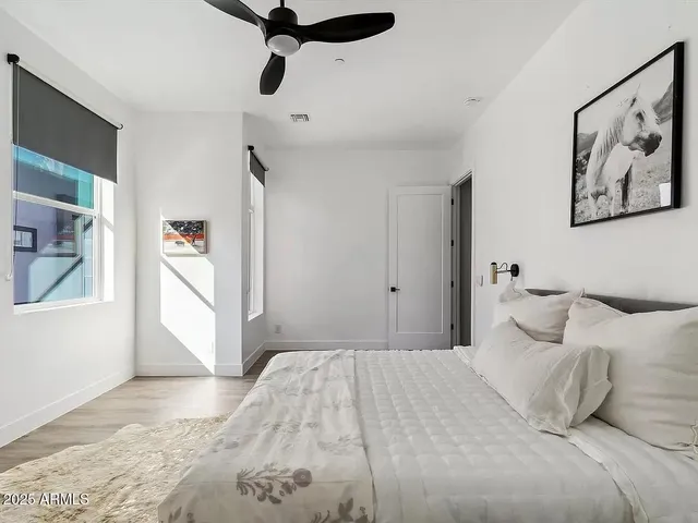 a bedroom with a large bed and a chandelier